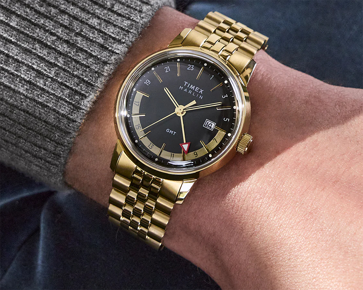 a gold timex gmt watch on a man's wrist