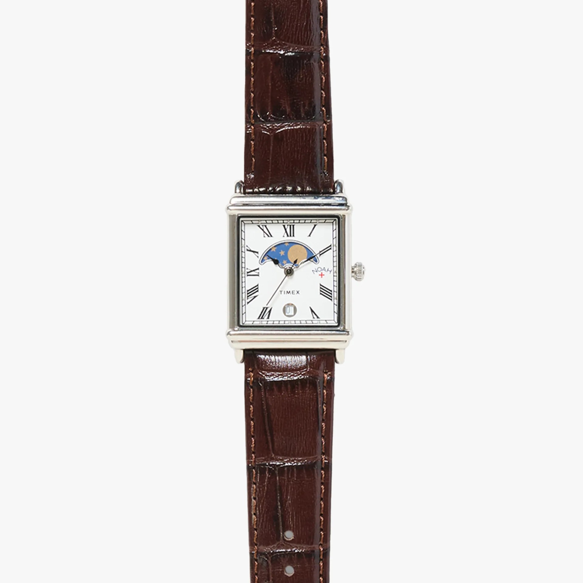 Rectangular silver watch with a white dial featuring black Roman numerals, a moon phase indicator at the top, and a small date window at the bottom. The watch has three silver hands and a brown leather strap with a crocodile pattern. The brand name "TIMEX" is printed above the date window.