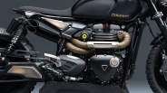 Close-up of a black Triumph motorcycle engine and exhaust system, featuring wrapped exhaust pipes, a matte black fuel tank with the Triumph logo, and rugged off-road tires. The bike has metallic and bronze accents on the footrest, side panel, and exhaust heat shield.
