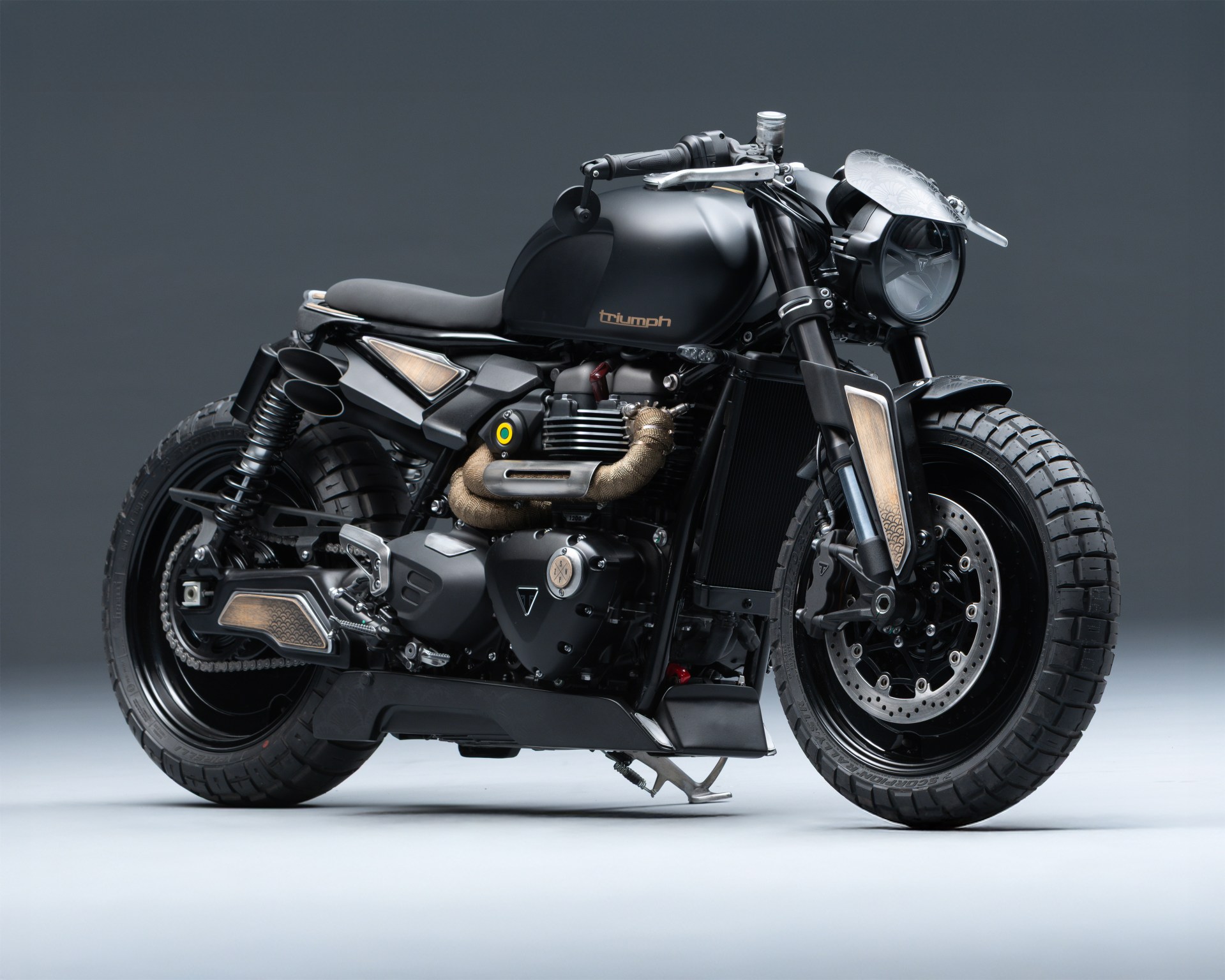 a photo of a custom triumph motorcycle on a studio background