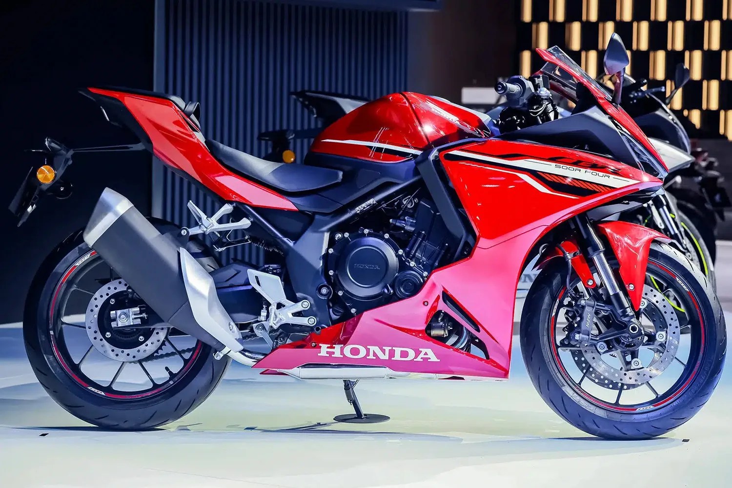 Red Honda sport motorcycle with black and silver accents, featuring a sleek aerodynamic design, visible exhaust pipe, and "500R FOUR" text on the front fairing.