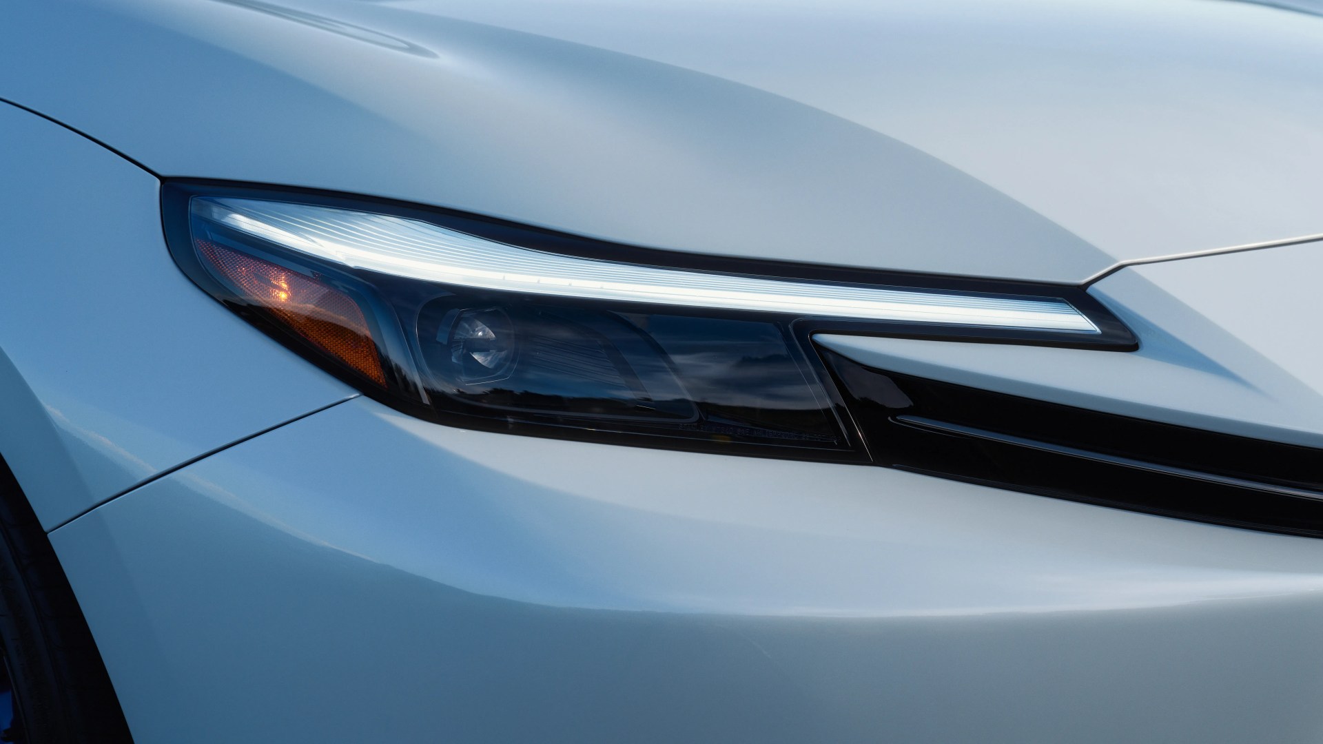 a close-up of a headlight on a white honda prelude