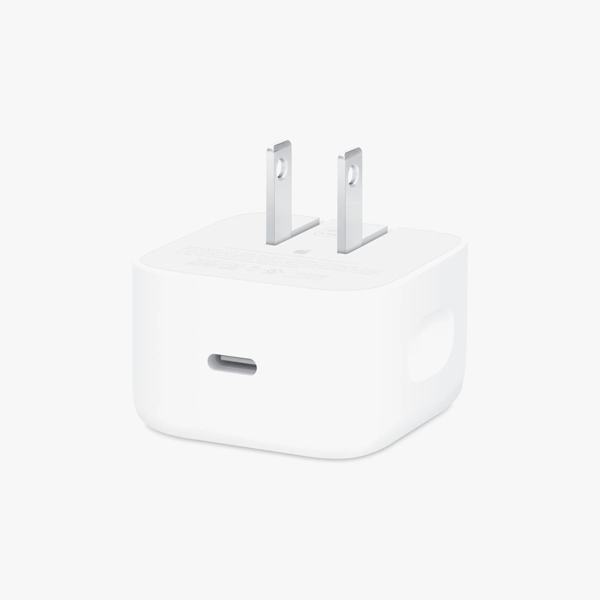 Compact white USB-C power adapter with two flat prongs for plugging into an electrical outlet. The adapter has a smooth, rounded rectangular shape.