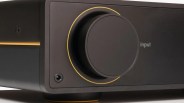 Close-up of a black audio device with a large circular knob outlined by a thin yellow ring, labeled "input." The device has a matte finish with a small screw visible near the bottom left corner.