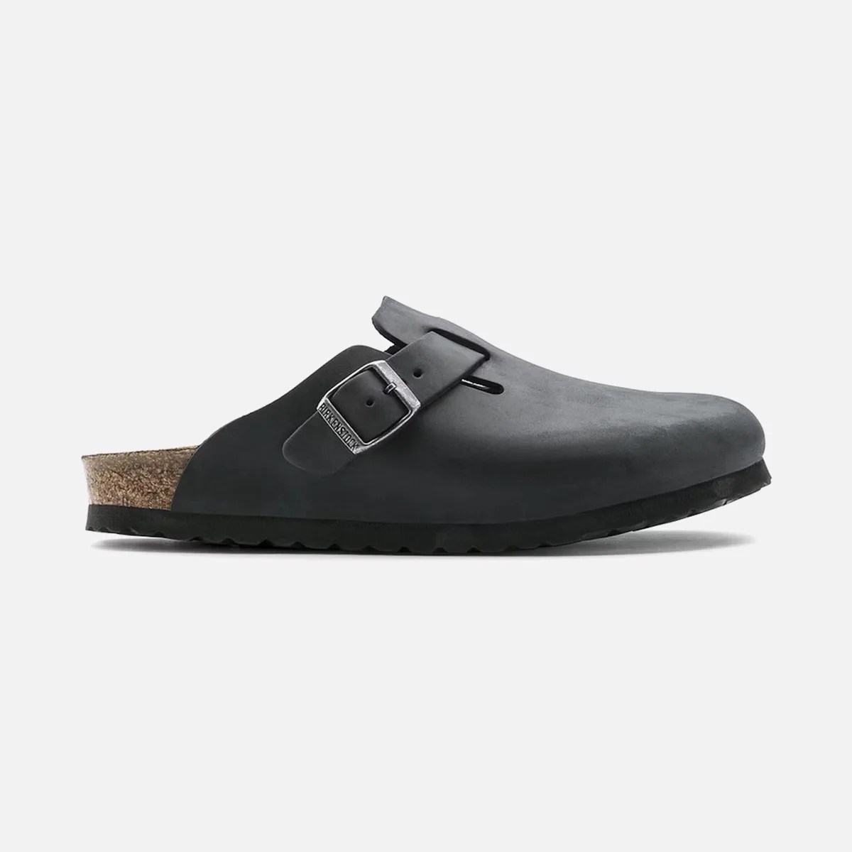 Black slip-on clog with a rounded toe, featuring a single adjustable strap with a silver buckle on the side. The shoe has a cork footbed and a black sole with a textured grip.