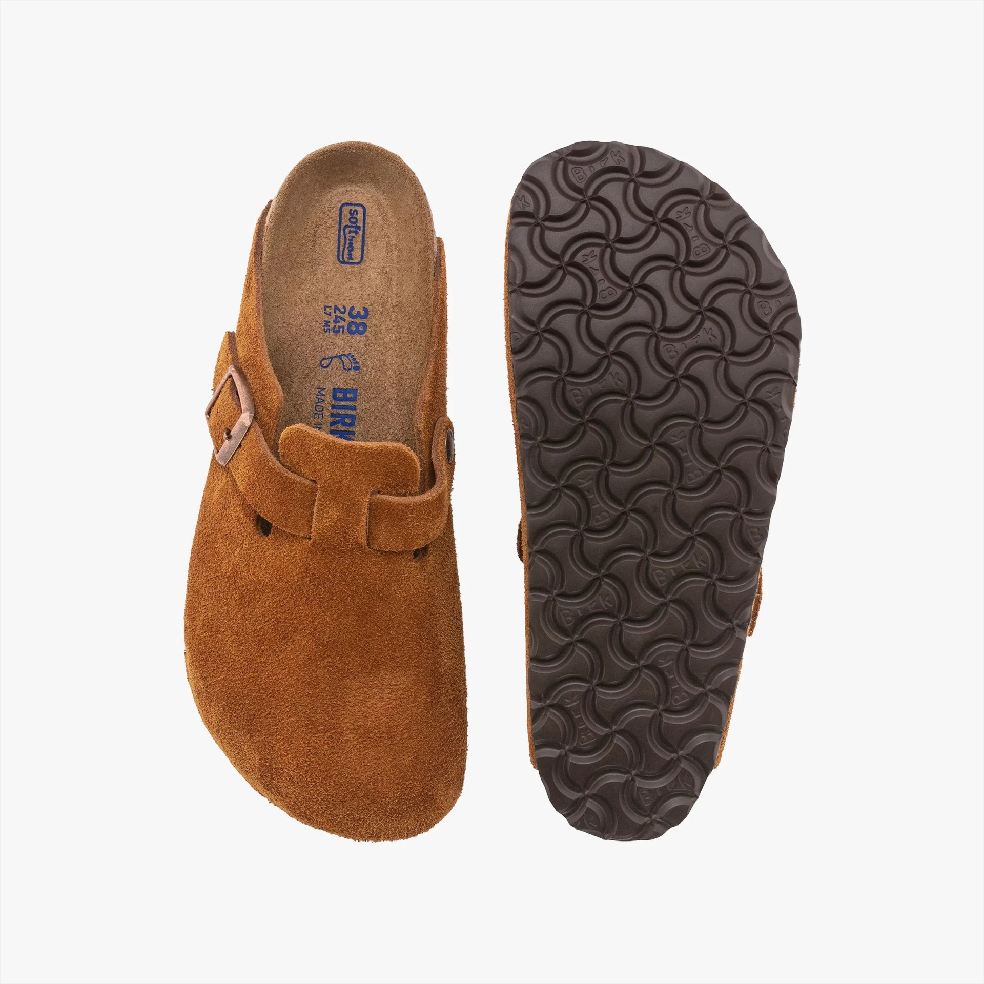 Brown suede Birkenstock clogs with a single adjustable strap and buckle across the top. The left clog shows the top view with a contoured footbed and blue printed size and brand details, while the right clog shows the textured black rubber sole with a wavy pattern.