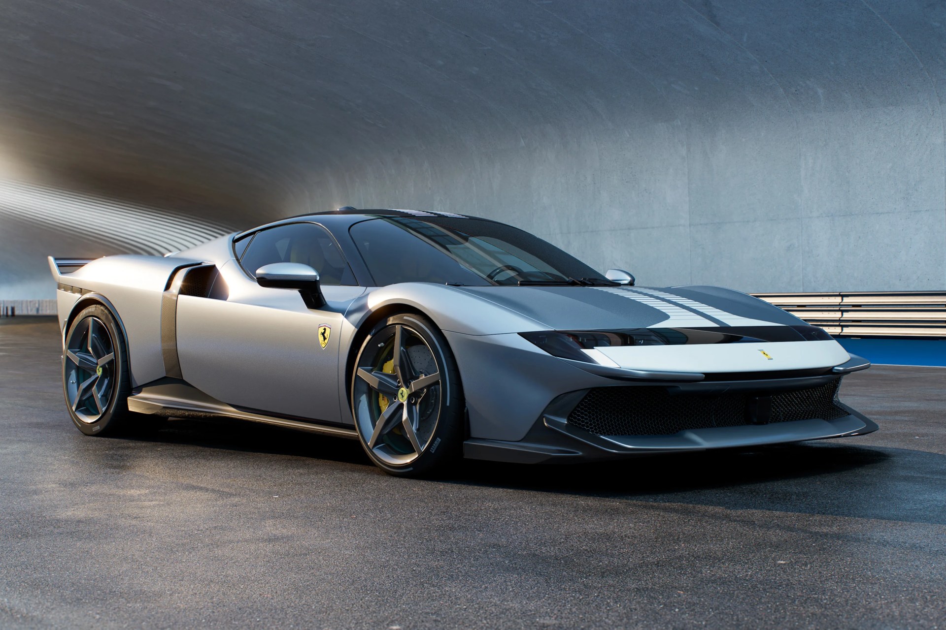 Silver Ferrari sports car with a sleek, aerodynamic design, featuring a low profile, black accents, and distinctive five-spoke wheels, parked on a smooth asphalt surface under a modern, curved concrete structure.