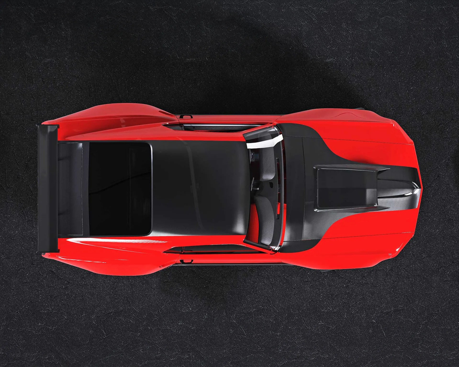 Red sports car with black accents viewed from above, featuring a large rear spoiler and aerodynamic design elements. The roof and hood have matte black sections, and the car is positioned on a dark textured surface.