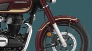 Close-up of the front section of a maroon Honda motorcycle, showing the fuel tank with the Honda logo, the engine with chrome and black components, the front suspension fork in silver, the front wheel with a disc brake, and a maroon front fender with cream-colored stripes.