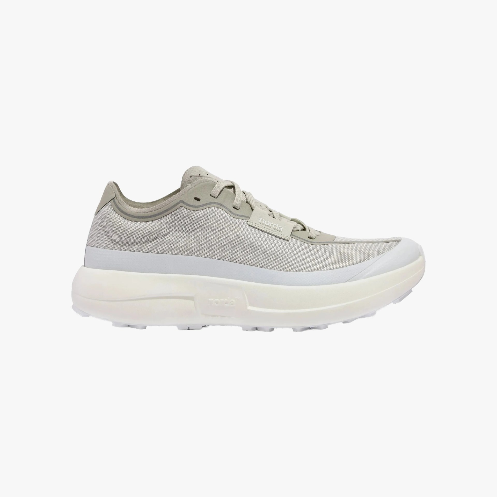 Light gray athletic sneaker with a mesh upper, lace-up closure, and a thick white cushioned sole. The shoe features subtle branding on a small tag near the laces and has a sleek, modern design.