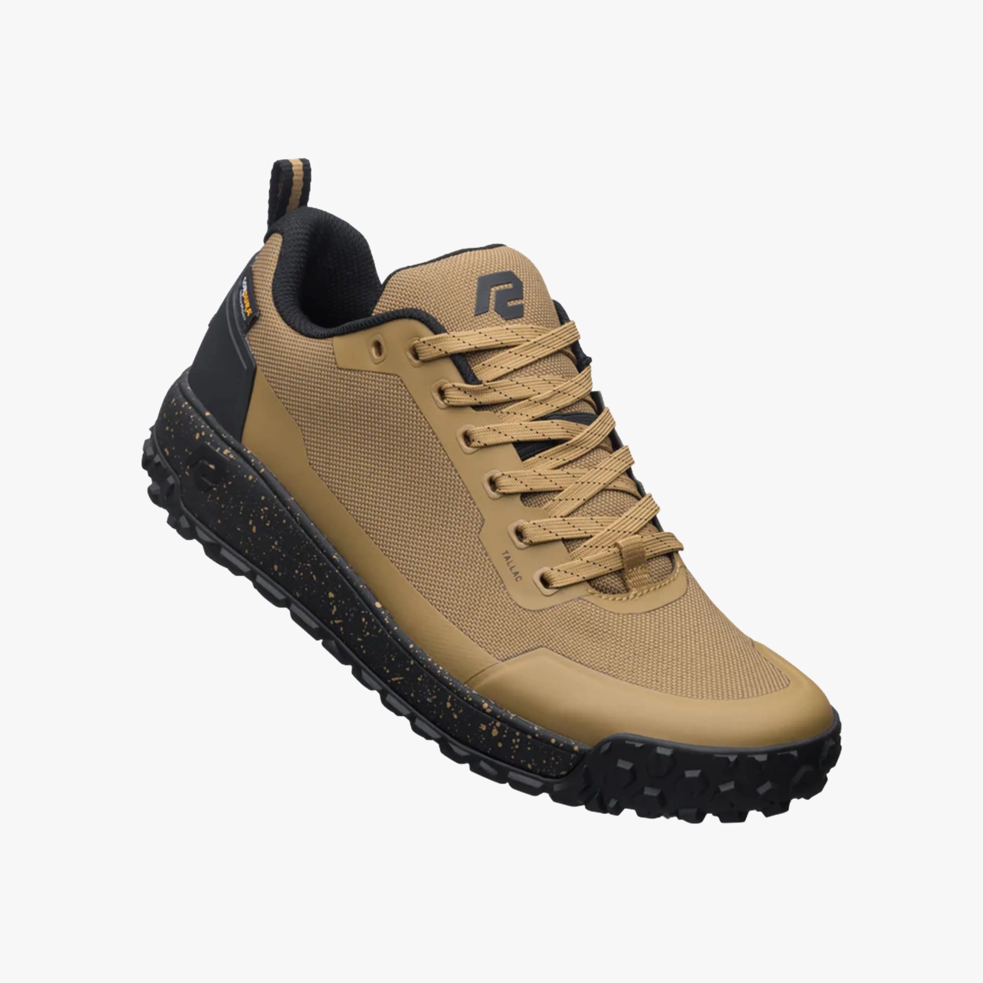 Tan and black athletic shoe with a textured mesh upper, tan laces, and a black speckled sole with rugged tread. The shoe features a pull tab at the heel and a logo on the tongue.