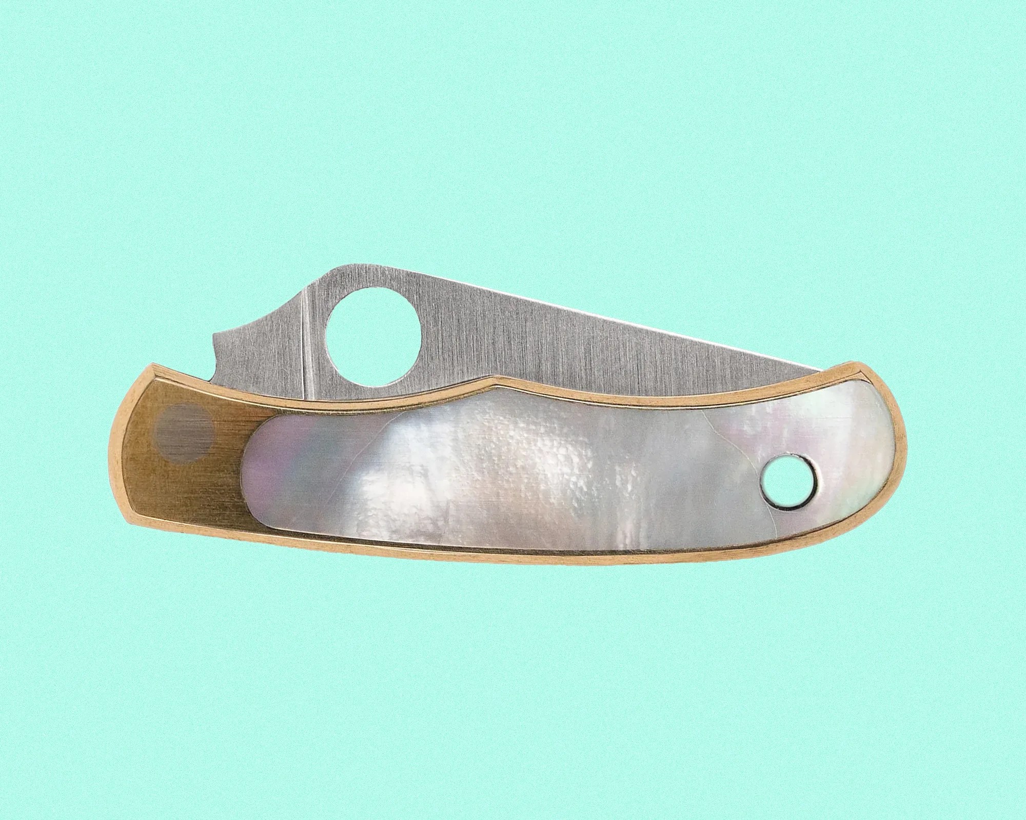 Folding pocket knife with a brushed metal blade and a handle featuring a mother-of-pearl inlay bordered by a light wood frame. The blade has a circular hole near the base for easy opening. The background is a solid light turquoise color.