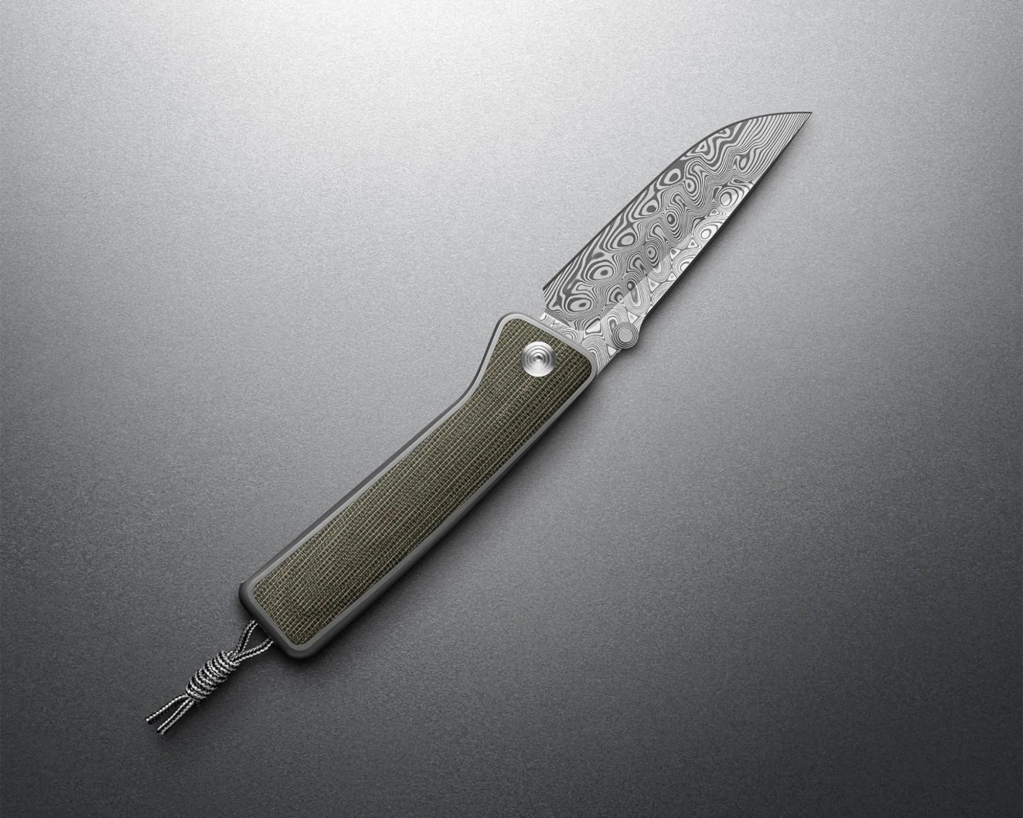 Folding knife with a patterned Damascus steel blade and a textured green handle. The handle has a metal frame and a lanyard hole with a black and white braided cord attached. The knife is displayed on a smooth, gradient gray surface.