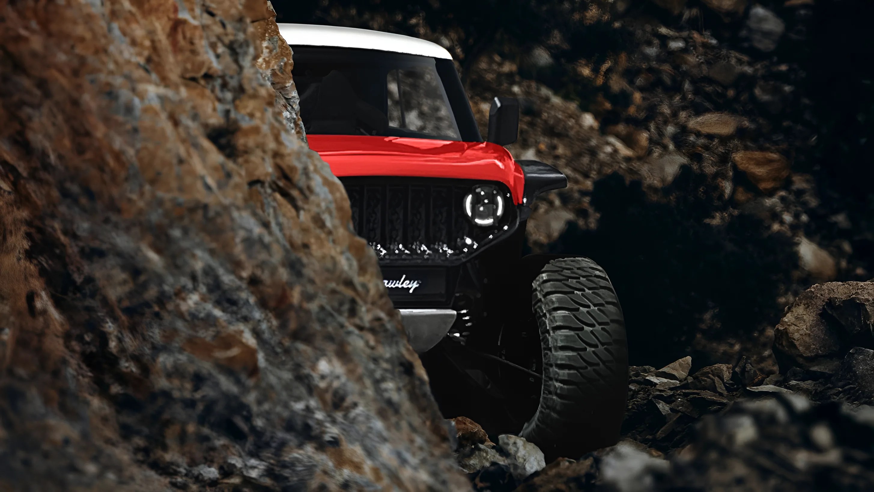 A red and white off-road vehicle with large tires is partially visible behind a rocky outcrop, navigating a rugged, rocky terrain. The vehicle's front grille and one headlight are clearly seen, with the headlight illuminated. The background is dark and filled with rocks.
