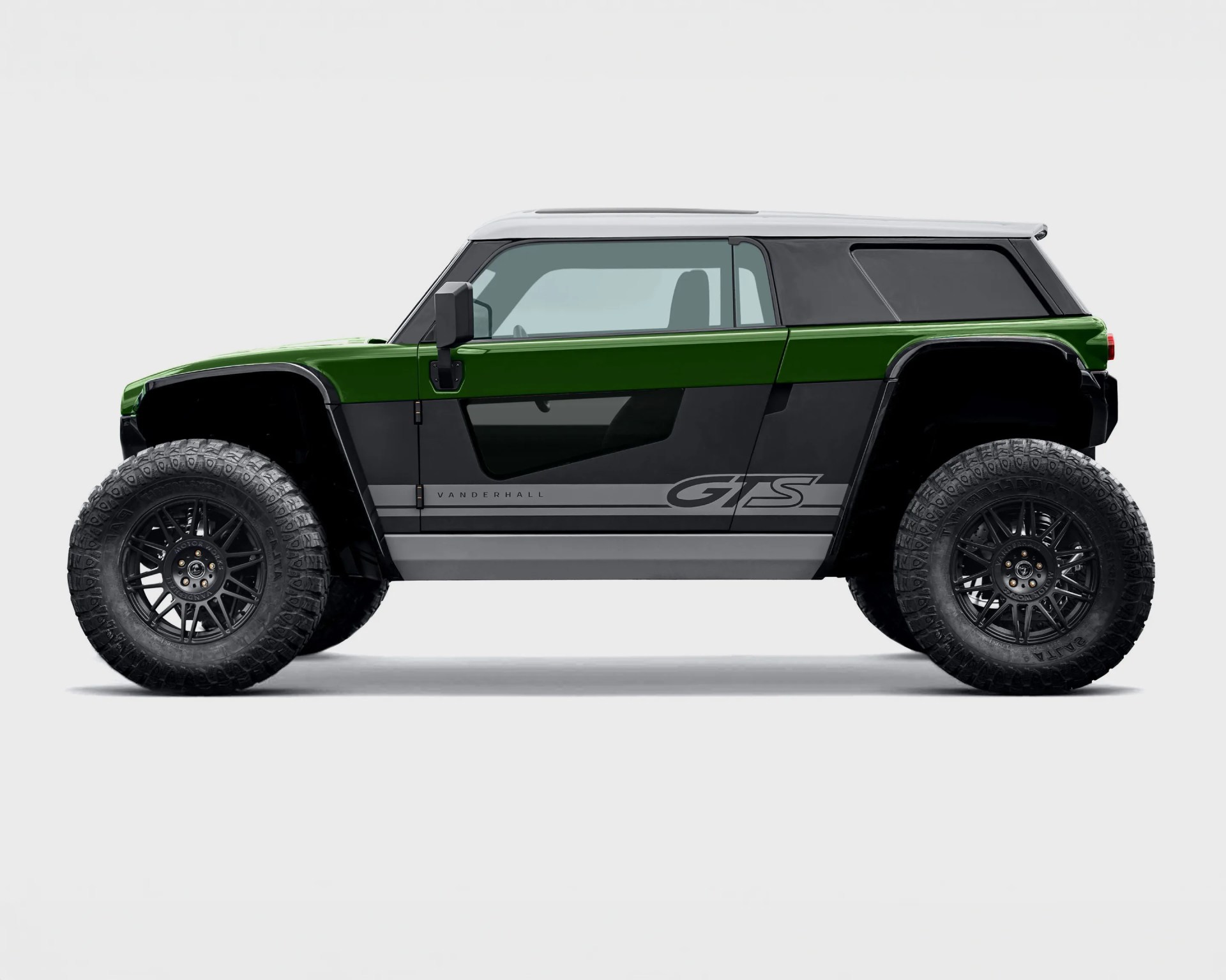Side view of a rugged off-road vehicle with a green upper body, black lower body, and gray accents. It features large, knobby tires with black rims, a white roof, and tinted windows. The vehicle has "Vanderhall" and "GTS" branding on the side.
