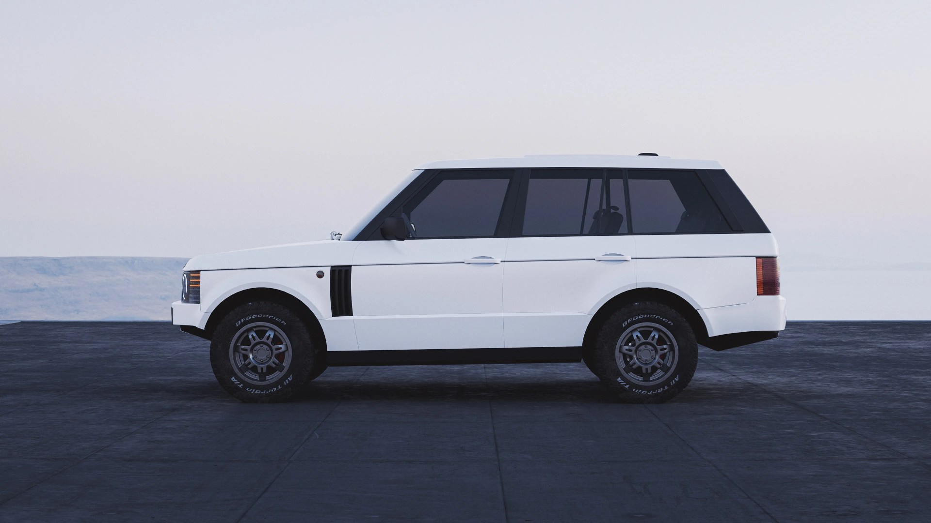 White SUV with a boxy design, tinted windows, black side mirrors, and BFGoodrich All-Terrain T/A tires, parked on a dark paved surface with a light sky background.