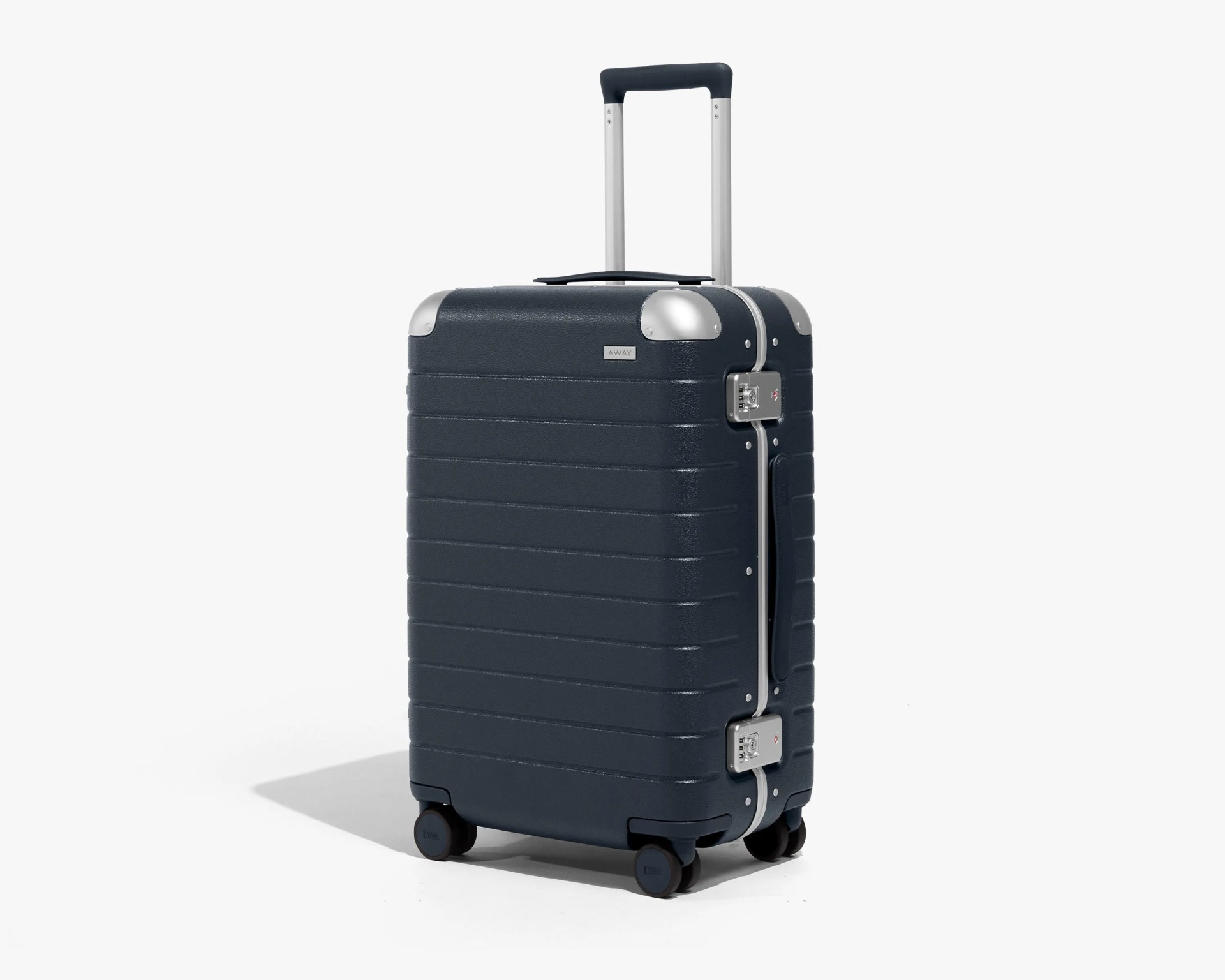 Dark blue hard-shell suitcase with horizontal ridges, silver metal corner protectors, and a retractable handle. It has four black spinner wheels and two combination locks on the side. The suitcase also features a side handle and a small rectangular logo plate near the top.
