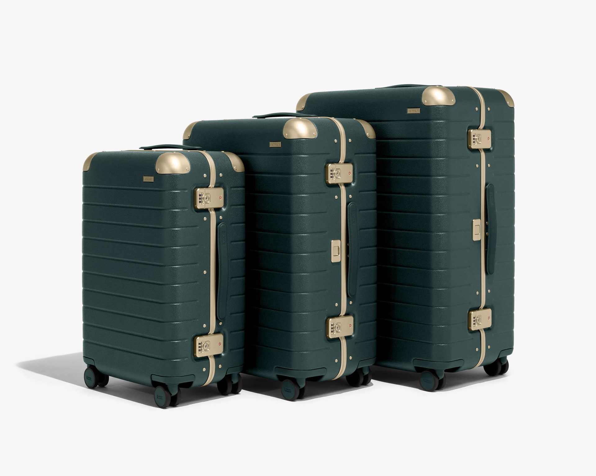 Three dark green hard-shell suitcases with gold corner protectors, gold zippers, and gold combination locks. Each suitcase has four black spinner wheels and a black side handle. The suitcases are arranged in ascending size order from left to right.