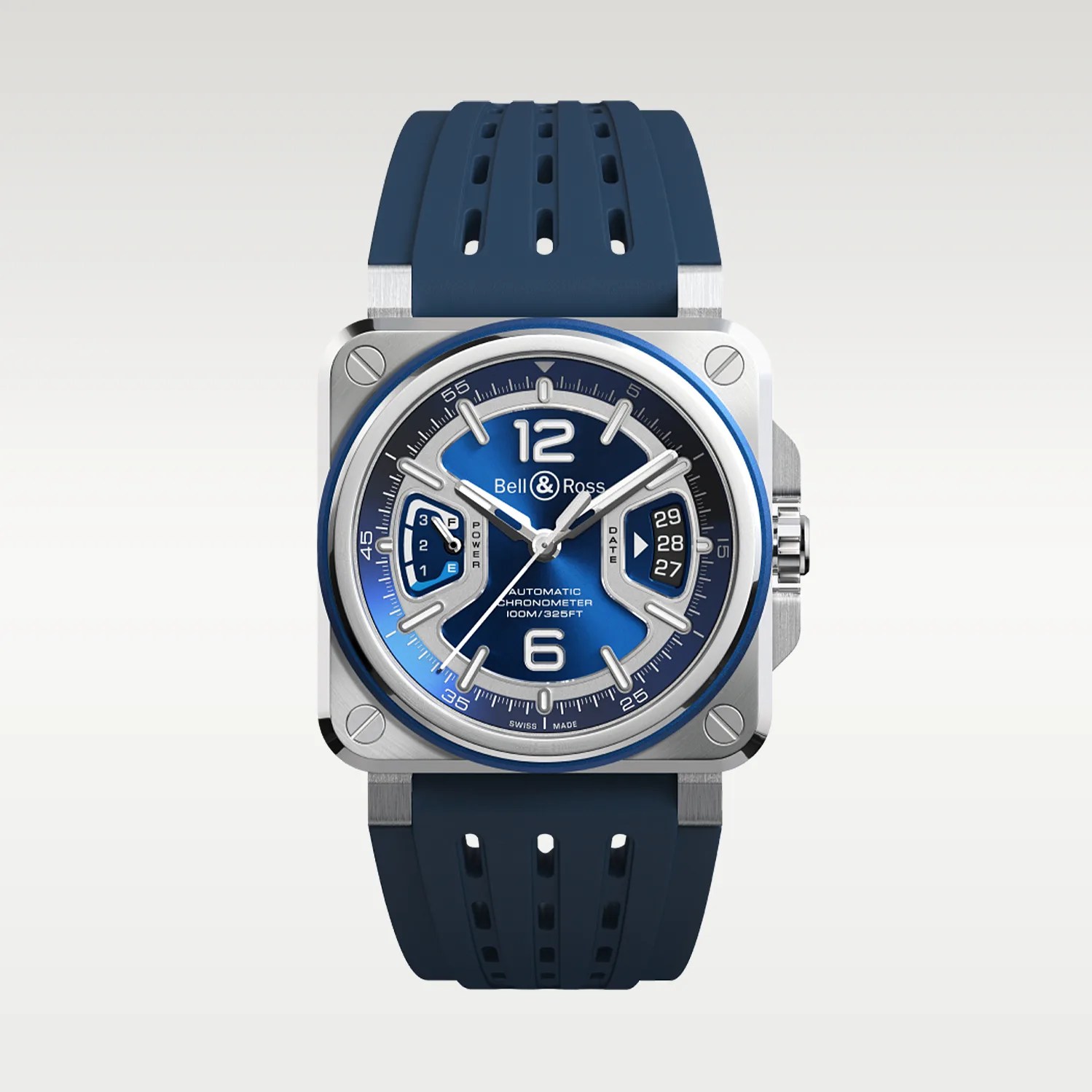 Square stainless steel wristwatch with a blue dial and matching blue perforated rubber strap. The dial features large white numerals at 12 and 6, silver hour markers, and two subdials: a power reserve indicator on the left and a date display on the right. The watch hands are silver with white accents, and the bezel has a blue ring. The brand name "Bell & Ross" is displayed below the 12 o'clock position.