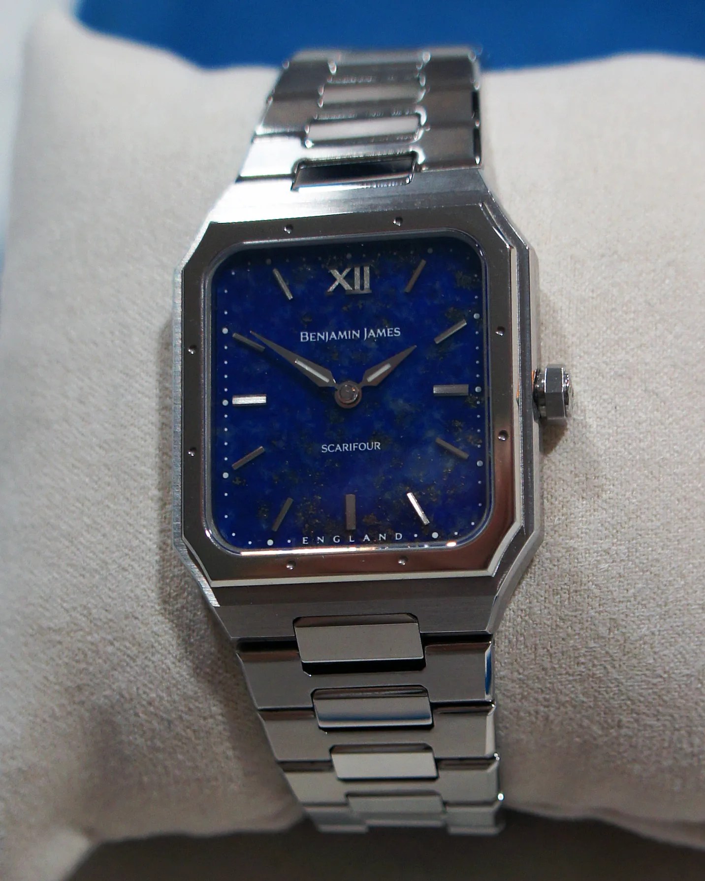 Silver rectangular wristwatch with a blue speckled dial, featuring silver hour markers and hands. The dial displays the brand name "BENJAMIN JAMES," the model name "SCARIFOUR," and "ENGLAND" at the bottom. The watch has a silver metal link bracelet and a crown on the right side.