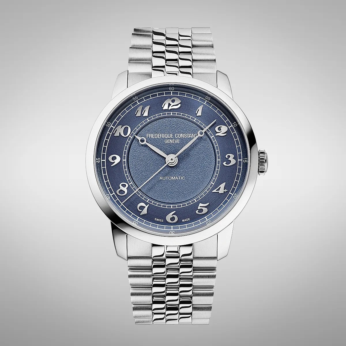 Silver Frederique Constant wristwatch with a textured blue dial, featuring silver Arabic numerals and three hands. The watch has a polished stainless steel case and a matching metal link bracelet. The dial includes the text "FREDERIQUE CONSTANT GENEVE," "AUTOMATIC," and "SWISS MADE.