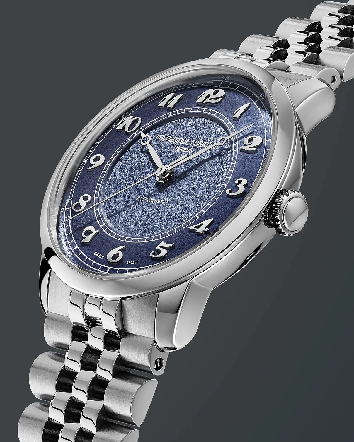 Silver wristwatch with a textured blue dial featuring raised silver Arabic numerals and silver hands. The watch face displays "FREDERIQUE CONSTANT GENEVE" and "AUTOMATIC" along with "SWISS MADE" at the bottom. The watch has a polished stainless steel case and a linked metal bracelet. The background is dark gray.