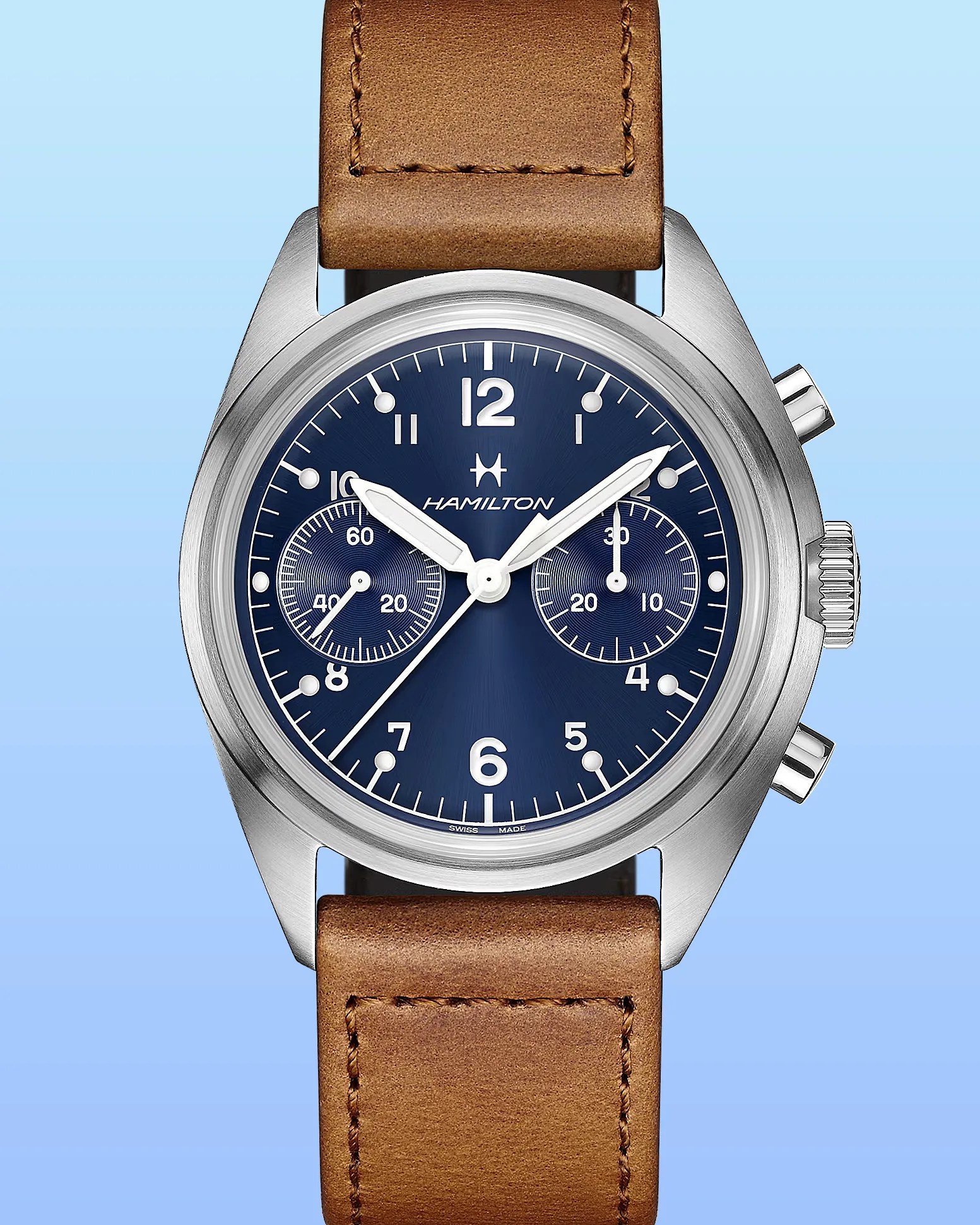 Hamilton wristwatch with a stainless steel case, blue dial, and white numerals and markers. It features two subdials, white hour and minute hands, and a brown leather strap with visible stitching. The watch has two push buttons and a crown on the right side.