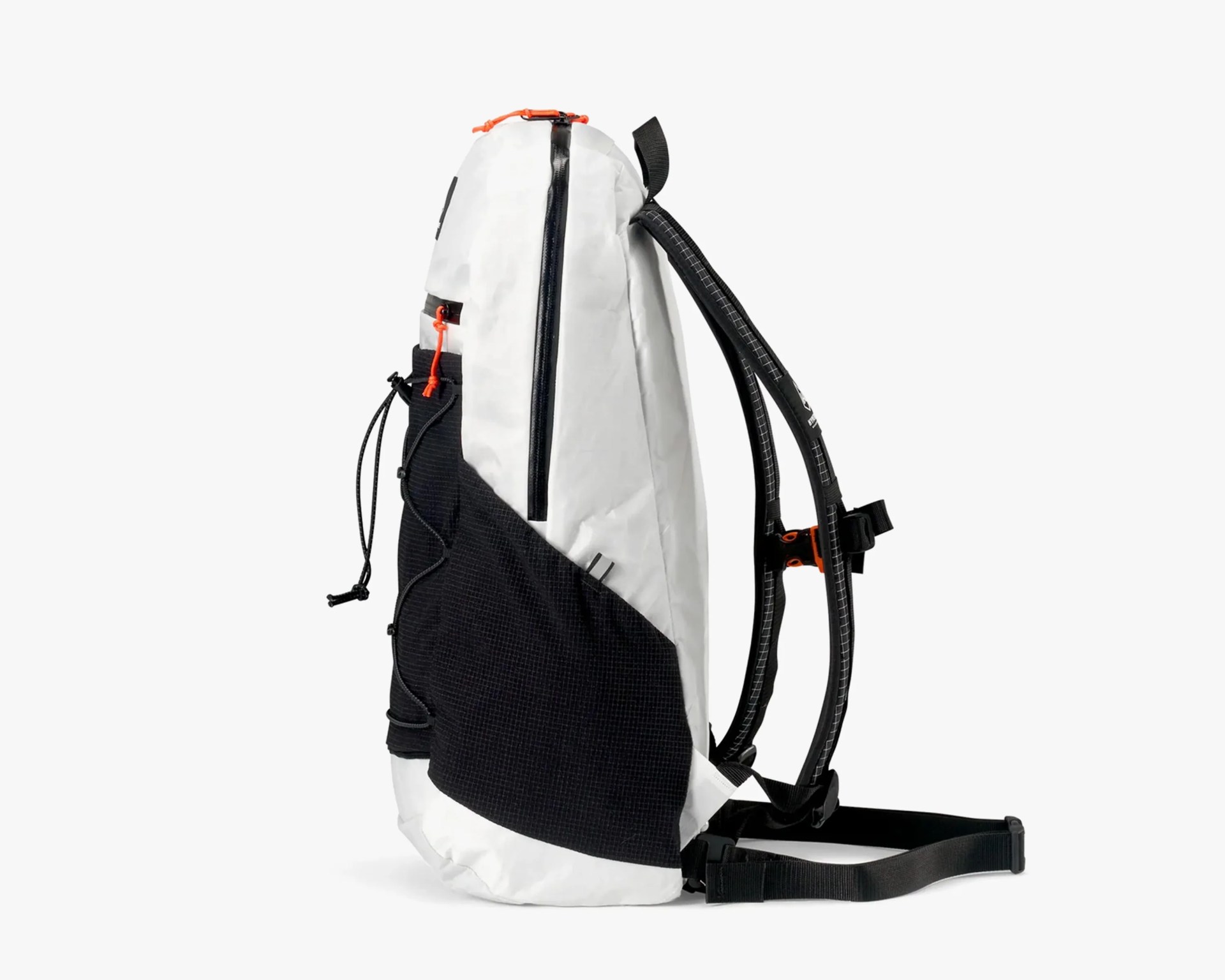 White and black backpack with a tall, slim profile. The main body is white with a large black mesh pocket on the side. It features black padded shoulder straps with white stitching and an adjustable black waist strap. There are orange zipper pulls and a vertical black zipper on the side. The top has a small orange loop.
