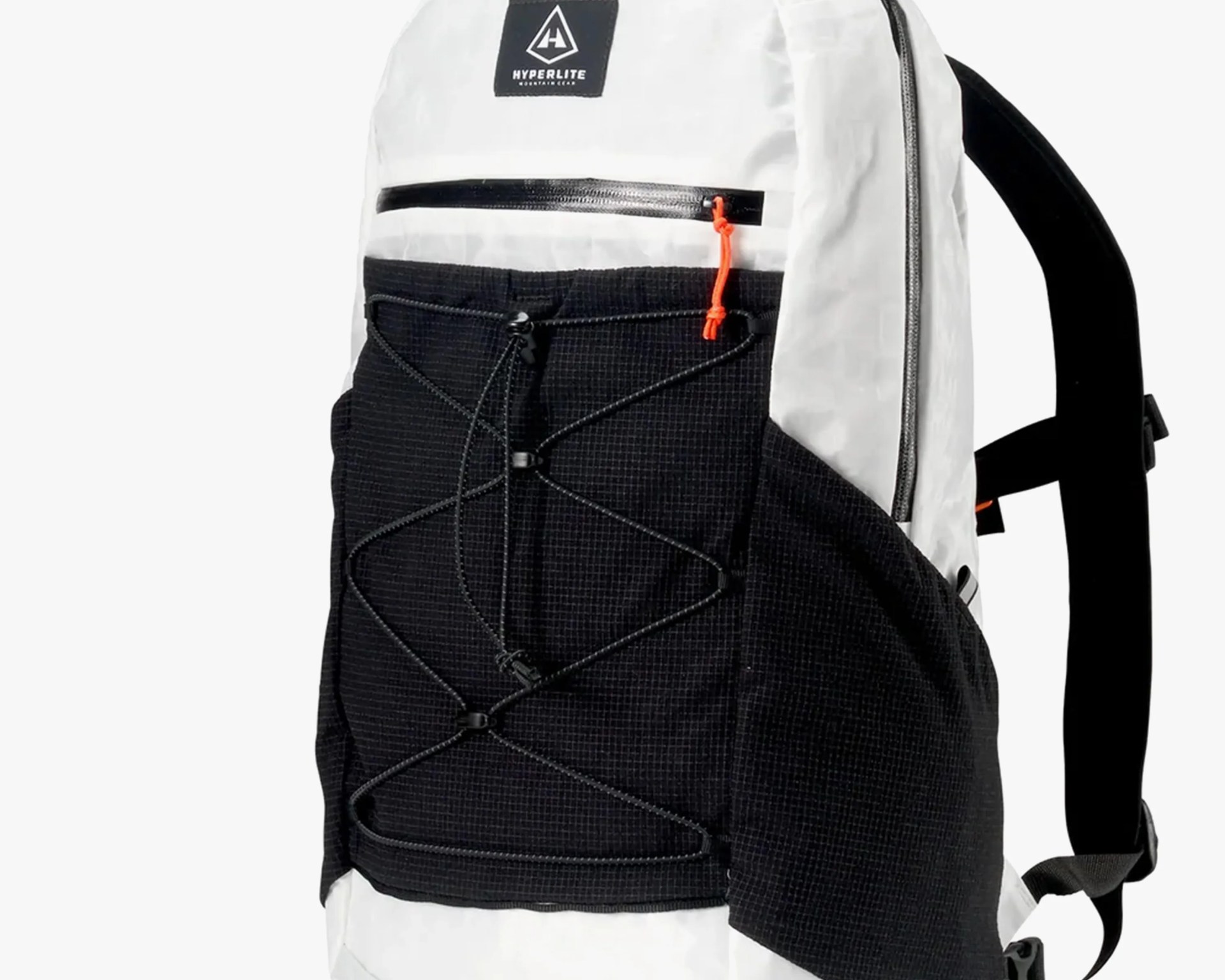 White and black backpack with a front black mesh pocket featuring an adjustable bungee cord system. The backpack has a small zippered pocket above the mesh pocket with an orange zipper pull. The brand logo "Hyperlite Mountain Gear" is displayed on a black patch near the top. The shoulder straps are black.