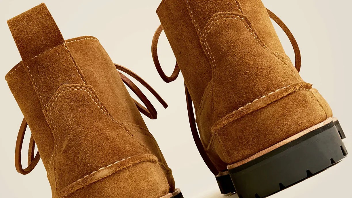 Pair of brown suede boots with visible stitching, leather pull tabs at the back, and black rubber lug soles.