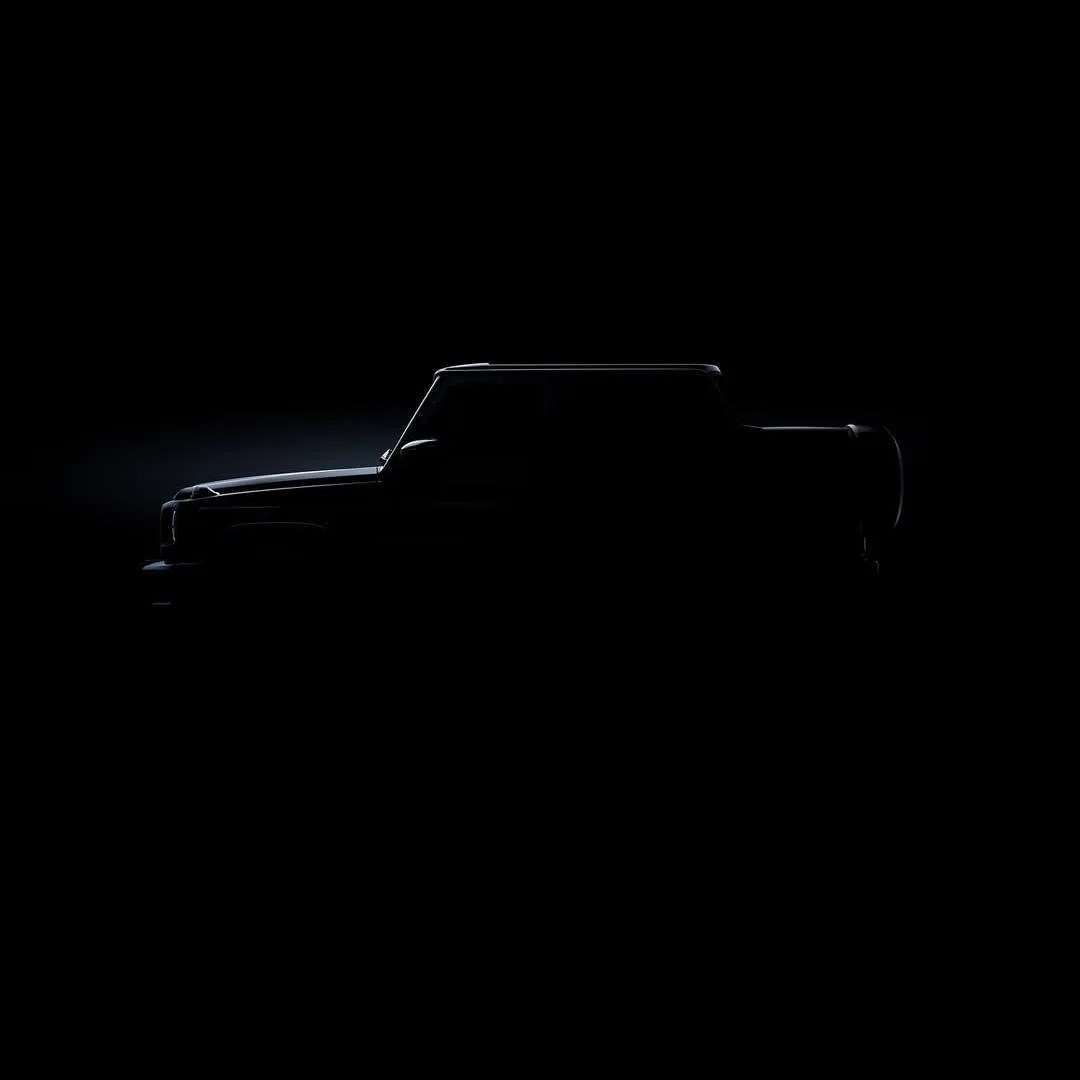 Silhouette of a boxy SUV with a spare tire mounted on the rear, highlighted by subtle edge lighting against a dark background.