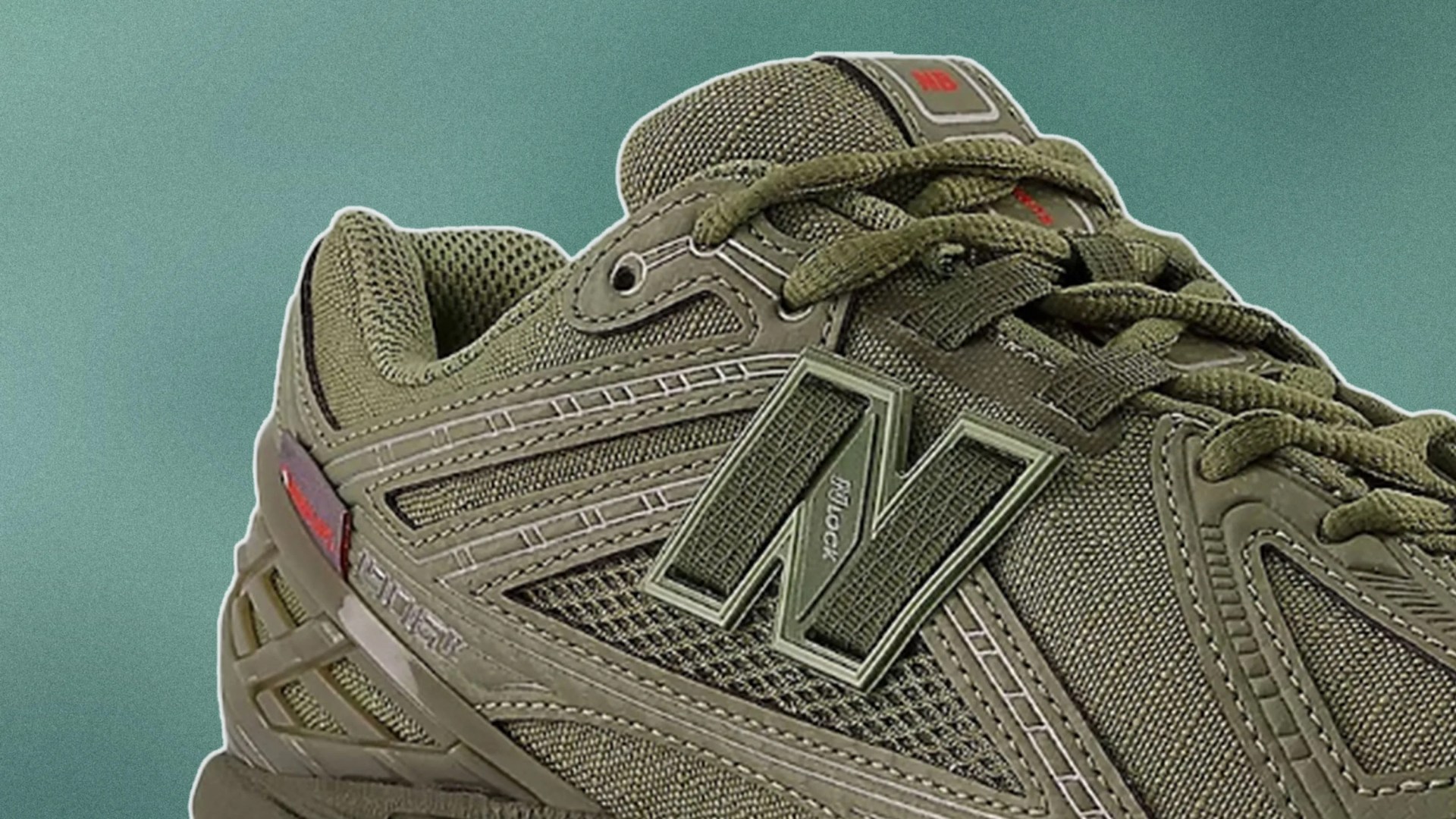 Close-up of an olive green New Balance sneaker featuring mesh and synthetic materials, with detailed stitching and the "N" logo on the side. The shoe has matching green laces and a padded collar. The background is a solid muted teal color.