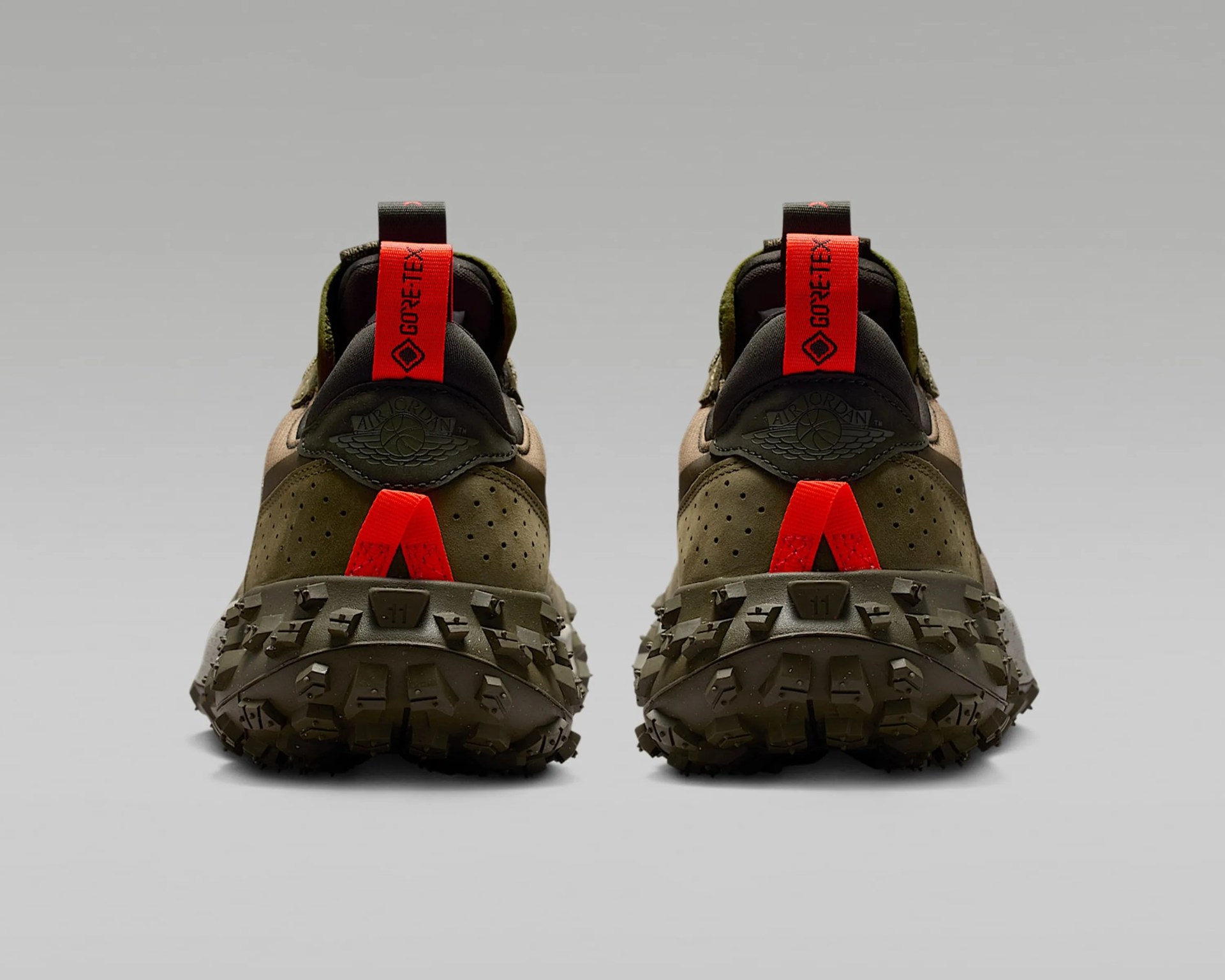 A pair of olive green Air Jordan sneakers shown from the back, featuring rugged, heavily textured soles for traction. The shoes have bright red pull tabs with "GORE-TEX" branding and a red loop detail above the sole. The Air Jordan logo is embossed on the heel area in black.