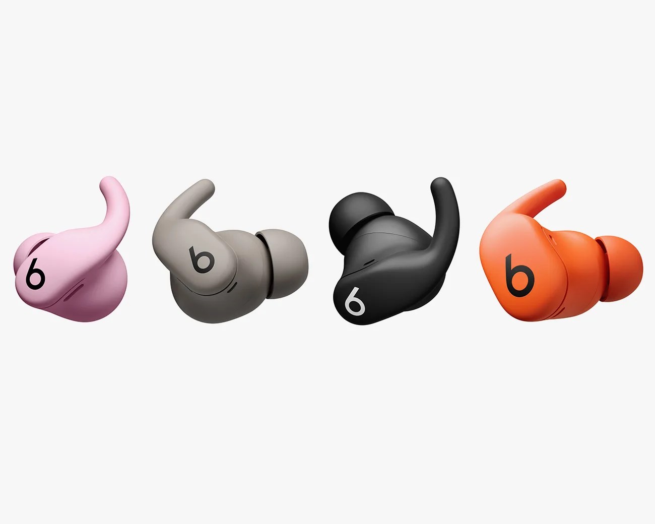 Four wireless earbuds in different colors—pink, gray, black, and orange—each featuring a curved hook design and the Beats logo on the outer side.