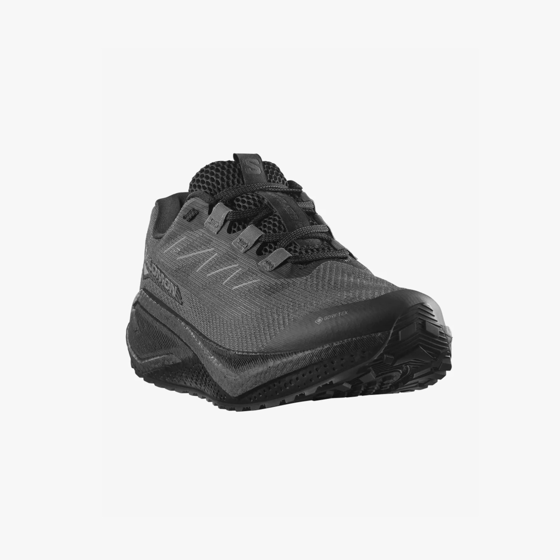 Black athletic shoe with a mesh upper, black laces, and a thick, textured sole. The shoe features a Gore-Tex label near the toe and the Salomon logo on the side. The design is sleek and modern, suitable for outdoor or trail running.