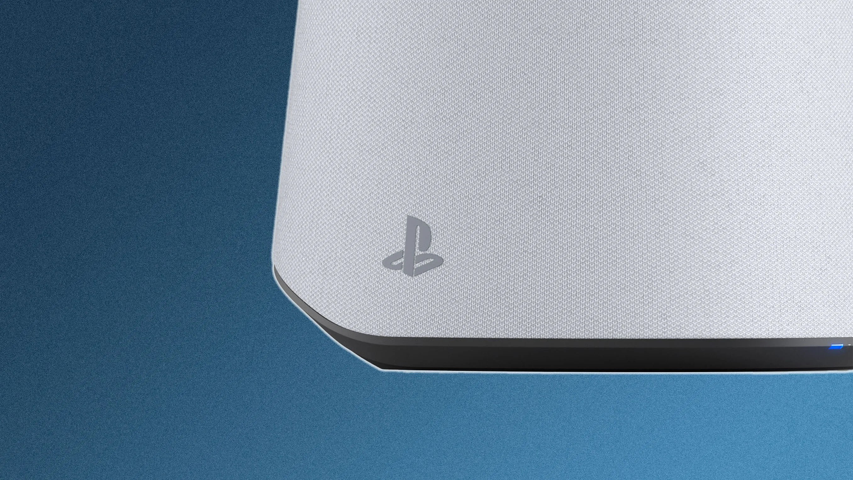 Close-up of the bottom corner of a white PlayStation 5 console, showing the textured surface, the PlayStation logo, and a small blue light on the black base against a blue background.