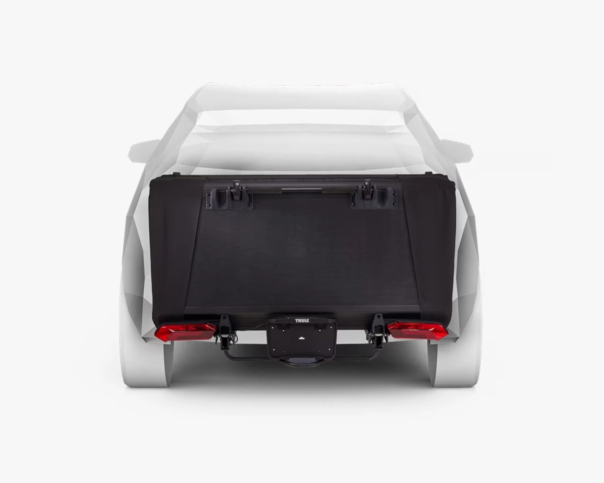 Black cargo box mounted on the rear of a white car, attached to a hitch carrier with integrated red tail lights and a central license plate holder labeled "Thule.