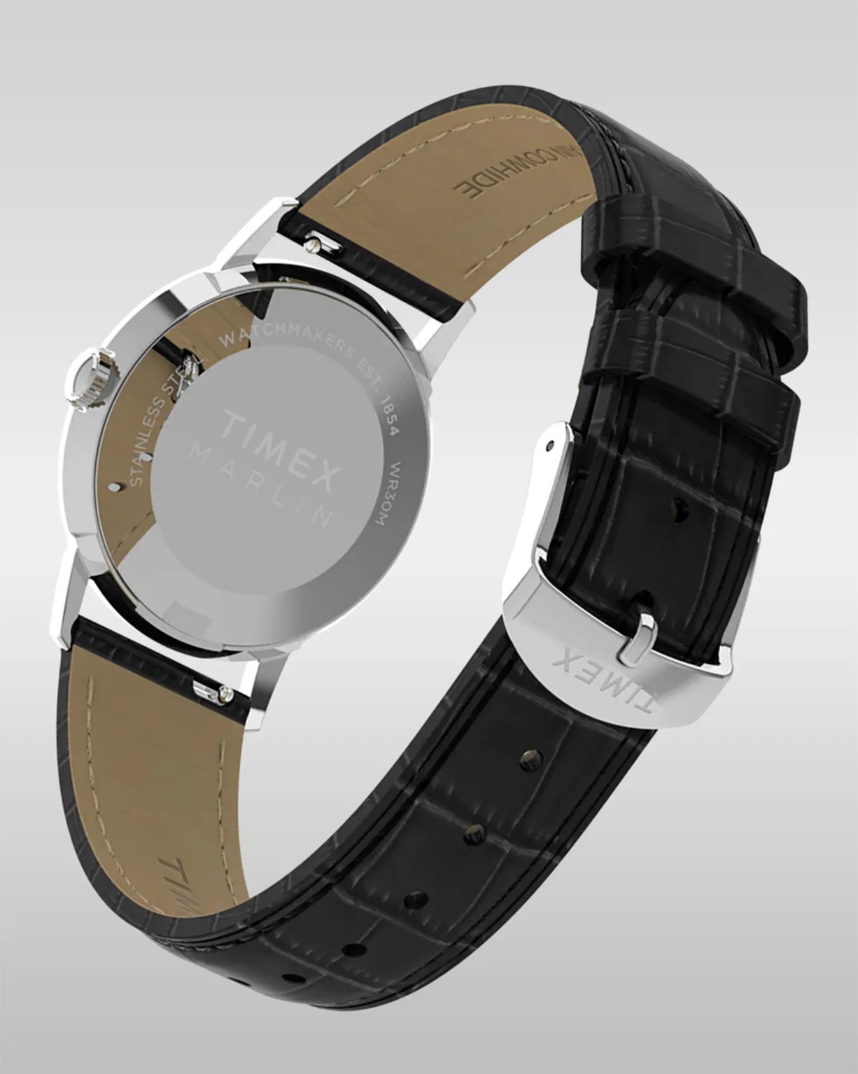 Silver Timex Marlin watch with a black leather strap featuring a crocodile pattern, visible stitching, and a silver buckle clasp engraved with "TIMEX." The back of the watch case is stainless steel and engraved with "TIMEX MARLIN," "WATCHMAKERS EST. 1854," and "WR30M." The inner side of the strap is tan with stitching and the Timex logo embossed.