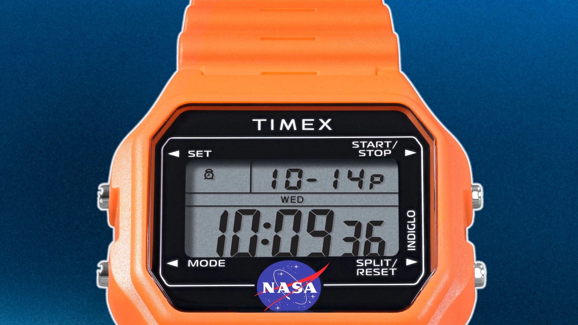 Digital Timex watch with an orange case and strap, displaying the time 10:09:36. The watch face shows the date as October 14, a Wednesday, and features the NASA logo at the bottom. The watch has buttons labeled SET, START/STOP, MODE, SPLIT/RESET, and INDIGLO.