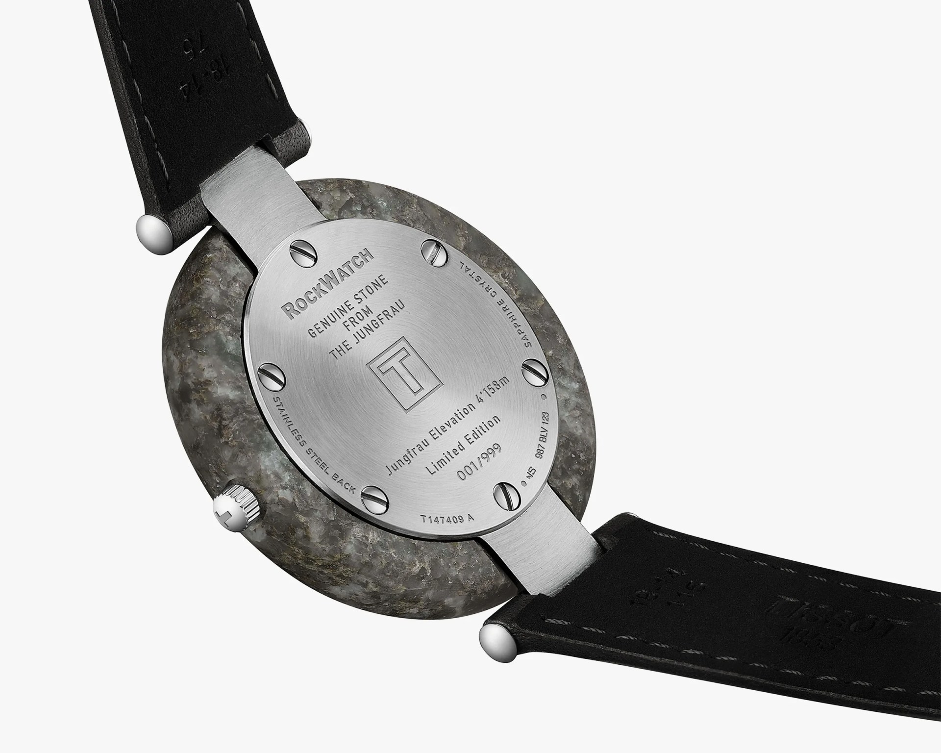 Back view of a RockWatch wristwatch featuring a genuine stone case from the Jungfrau mountain. The stainless steel back is secured with six screws and engraved with details including "RockWatch," "Genuine Stone from the Jungfrau," "Jungfrau Elevation 4158m," "Limited Edition 001/999," and "Sapphire Crystal." The watch has a black leather strap with visible stitching.