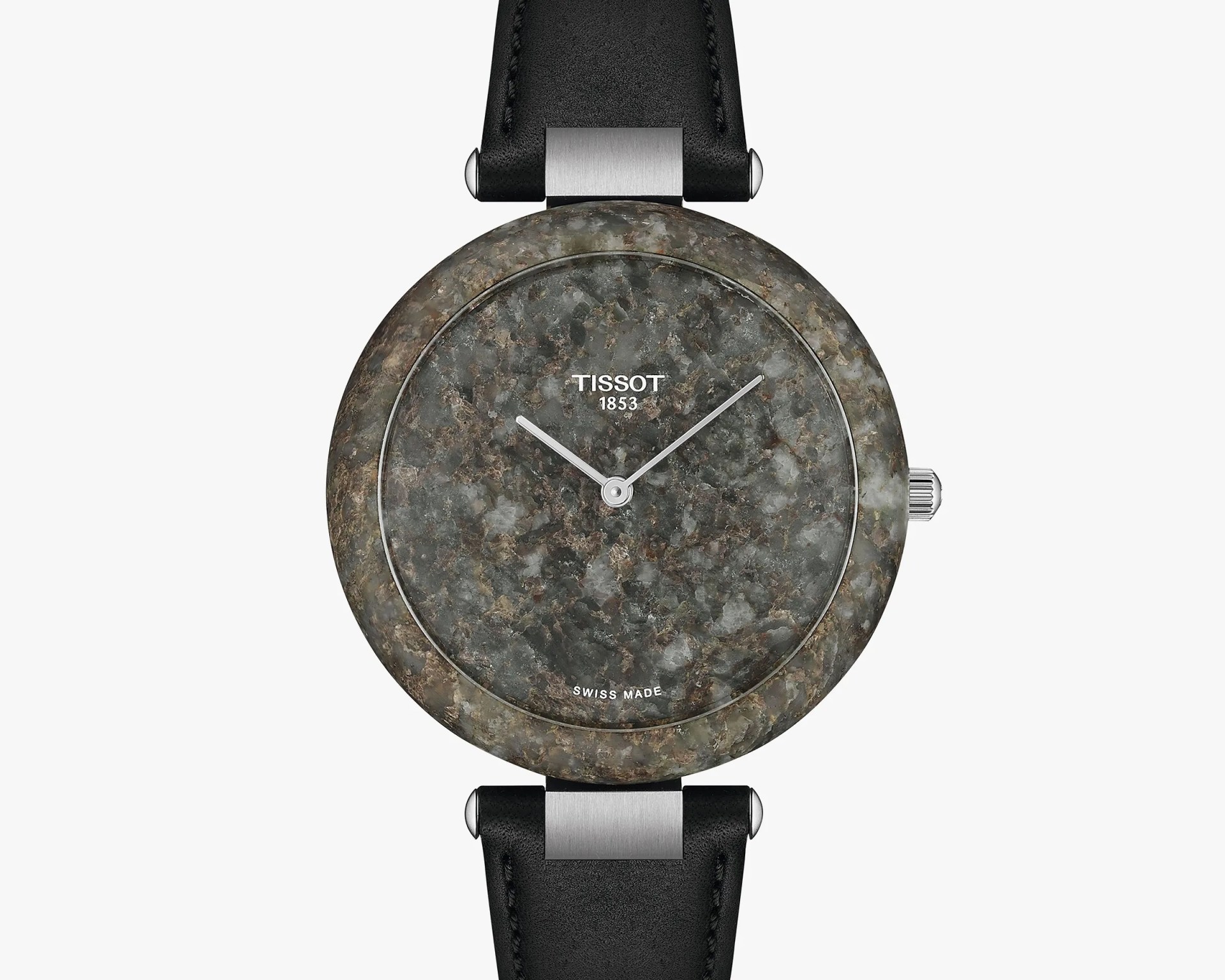 Round wristwatch with a textured stone-like gray and brown dial and bezel, featuring minimalist silver hour and minute hands. The watch face displays the brand name "TISSOT 1853" near the top and "SWISS MADE" near the bottom. It has a black leather strap with silver metal connectors attaching it to the watch case.