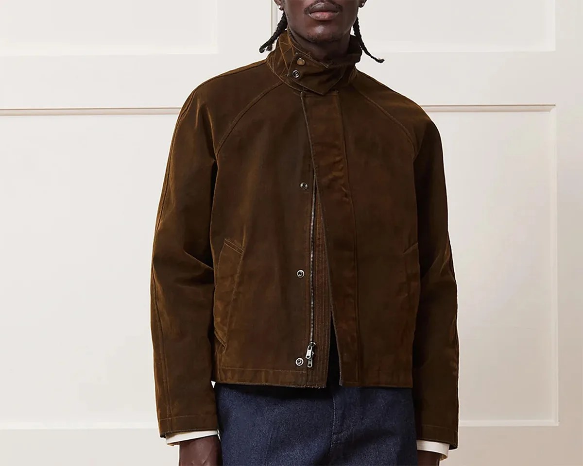 Brown corduroy jacket with a high collar featuring snap buttons, a front zipper closure covered by a snap-button placket, and side pockets. The jacket has long sleeves and a slightly cropped fit.