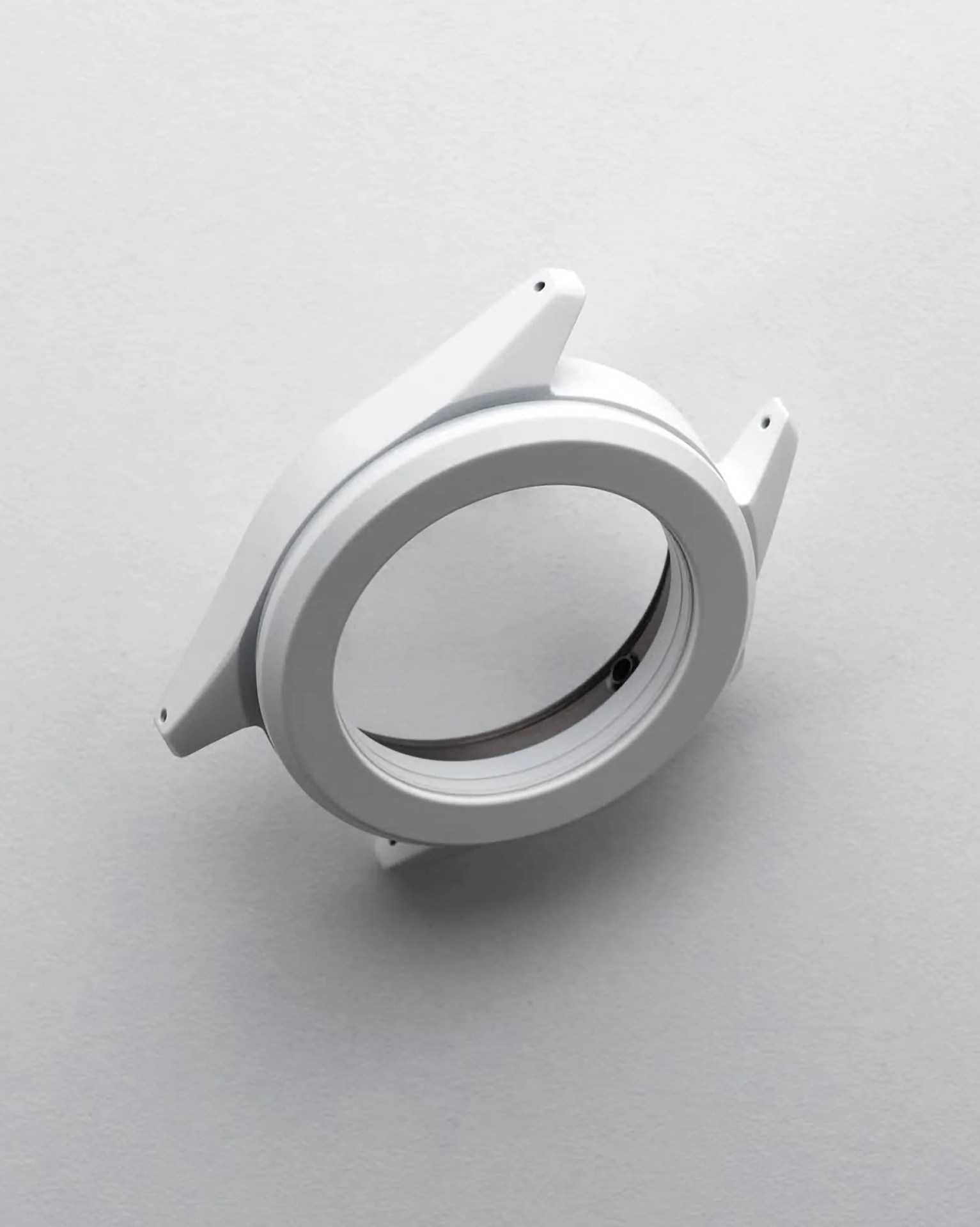 White circular watch case with lugs for attaching a strap, shown without the watch face or movement.