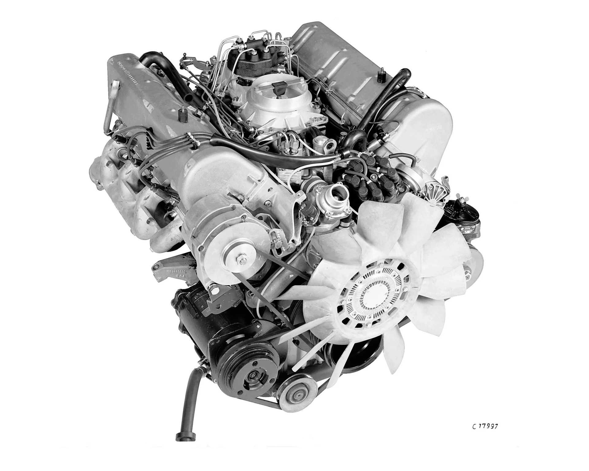 V8 internal combustion engine with cooling fan and multiple belts isolated on white background.