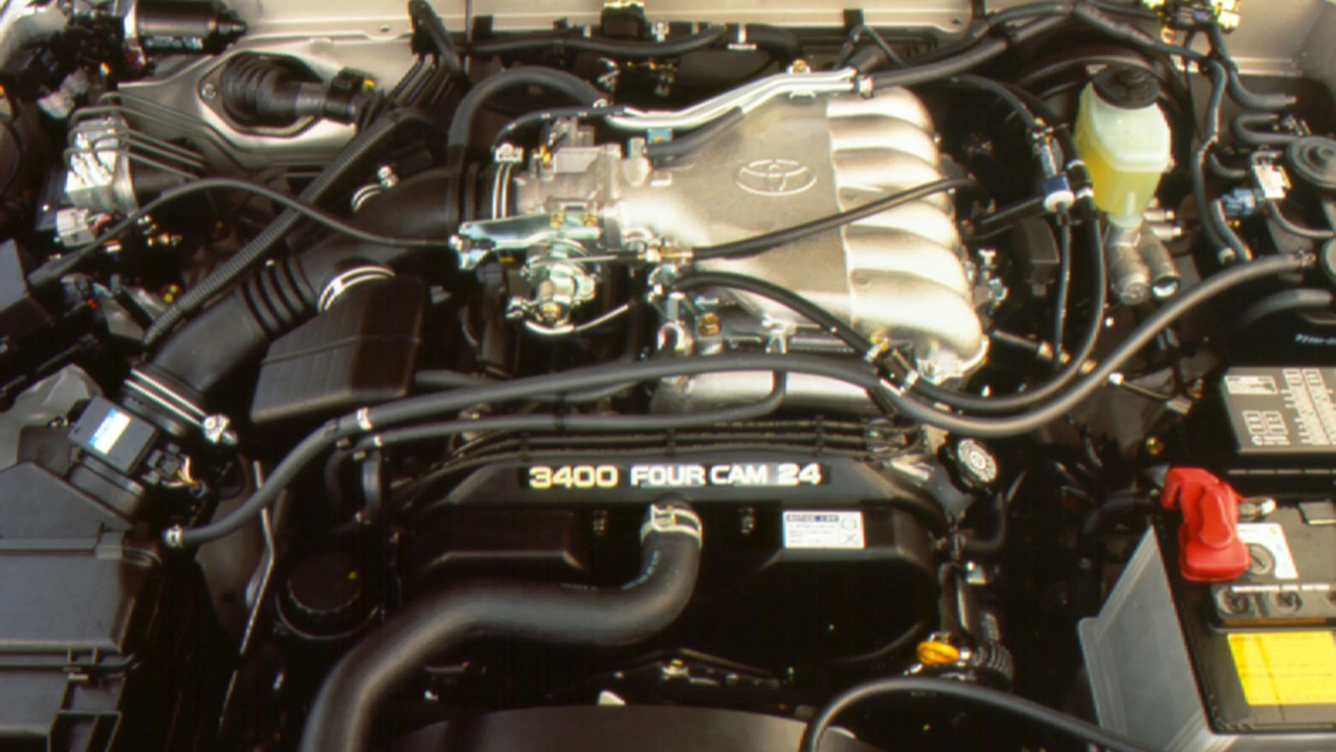 Toyota 3400 Four Cam 24-valve engine with visible intake manifold and battery.