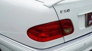 White car rear with red tail light and chrome "E 50" badge on the trunk.