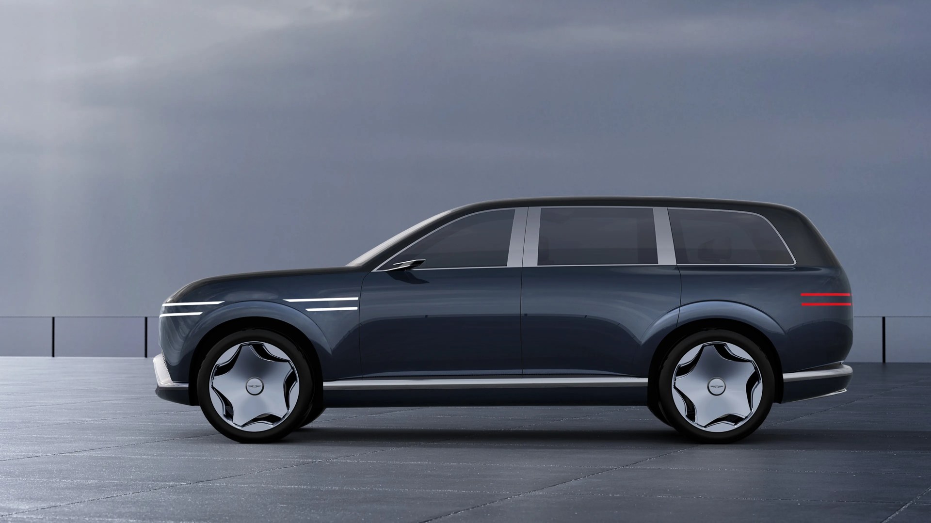 Dark blue luxury electric SUV with smooth curves and futuristic chrome wheels on a paved surface.