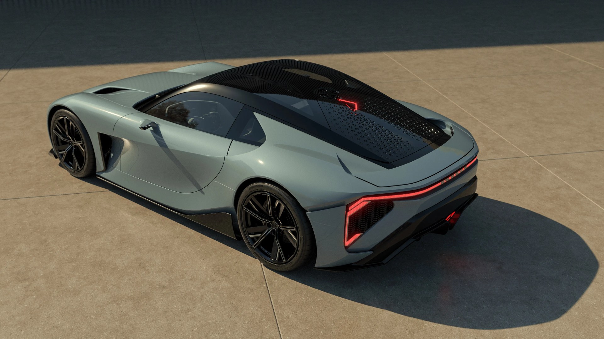 Sleek gray sports car with black roof and rear LED light strip parked on a concrete surface.