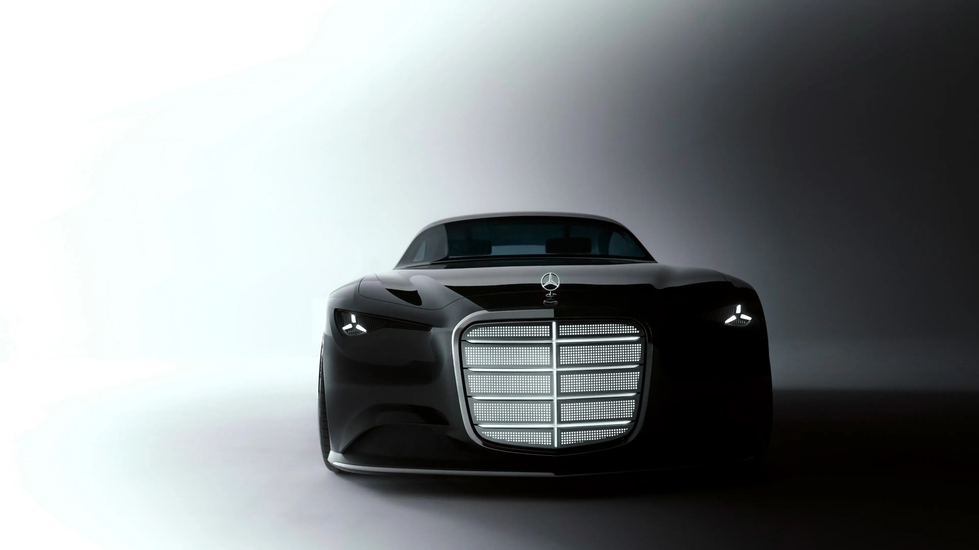 Front view of a sleek black Mercedes-Benz car with illuminated grille and headlights in a gradient light setting.