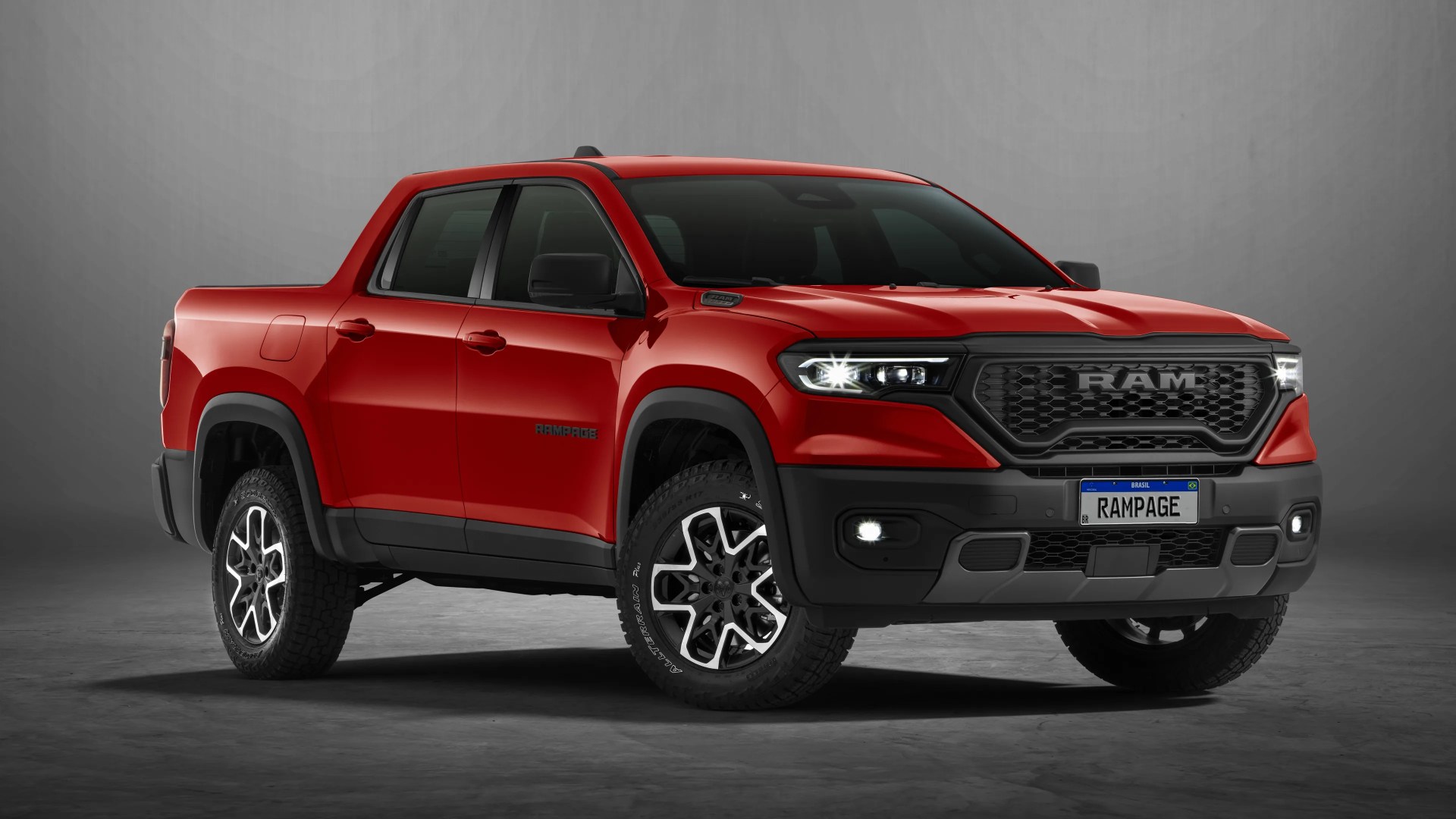 Red Ram Rampage pickup truck with black grille and off-road tires on a gray studio floor.